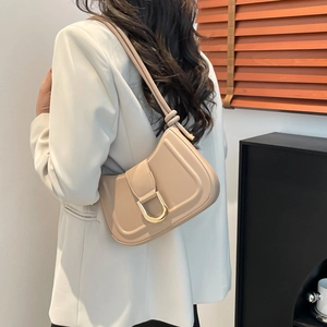 Minimalist beige dumpling hobo bag featuring a distinctive gold D-ring buckle