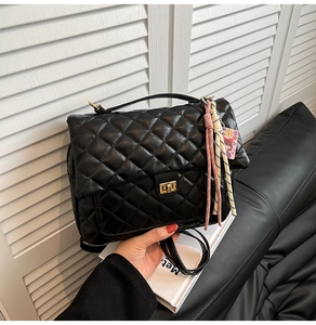 Detail der schwarzen gesteppten Rucksacktasche mit goldenem Drehverschluss und Quasten