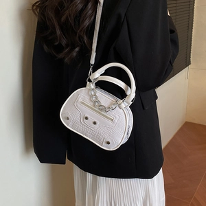 Borsa a tracolla bianca effetto coccodrillo con borchie indossata da modella in blazer