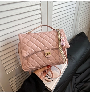 Detail der rosa gesteppten Schultertasche mit goldenem Drehverschluss und Anhänger