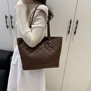 Deep brown quilted tote bag with diamond stitching and silver bow hardware detail