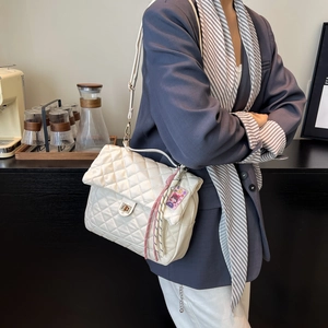 Elegante gesteppte beige Kettentasche mit goldener Schließe für modische Damenoutfits