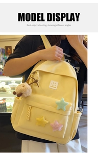 Detail of light yellow nylon backpack with plush stars and cute bear pendant charm
