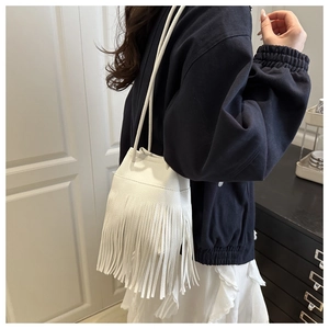 Détail du sac seau blanc avec texture cuir grainé et longues franges décoratives