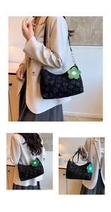Detail of black floral jacquard underarm bag with silver chain and green flower charm