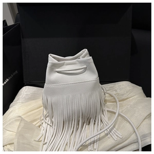 Détail du sac seau en cuir grainé blanc avec de longues franges et fermeture à cordon