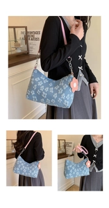 Detailed view of blue floral embroidery texture and pink leather chain strap on underarm bag