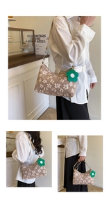Detail of floral embroidery on beige shoulder bag with metal chain and green flower charm