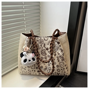 Detail of hand-woven tote bag featuring brown floral patterns and cute panda charm