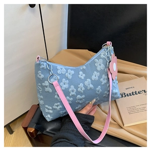 Detailed close-up of blue denim bag with 3D floral embroidery and pink leather strap