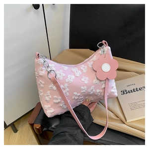 Detail of pink floral embossed underarm bag with white flower texture and charm