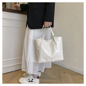 Detail view of cream vintage faux leather tote bag showing soft texture and strap buckle