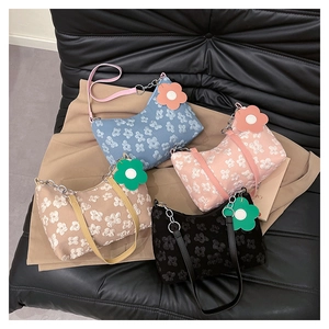 Detail of four printed shoulder bags with 3D floral textures and matching flower pendants