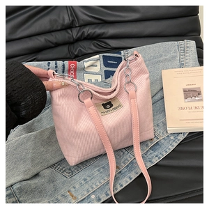 Close-up of pink corduroy tote bag featuring Myron Bear patch and leather chain straps