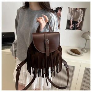Detail of dark brown vintage tassel backpack with faux leather and suede fringe details