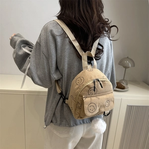 Minimalist beige corduroy backpack with smiley print and plush ball pendant for women