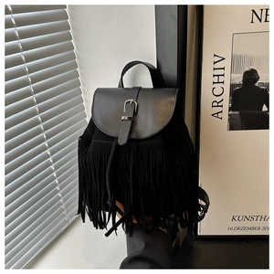 Detail view of bohemian black backpack featuring dense fringe and suede leather texture