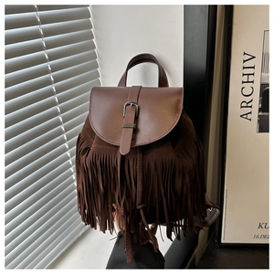 Close-up of bohemian brown fringe backpack with suede texture and metal buckle detail