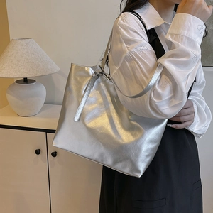 Minimalist silver faux leather tote bag with large capacity shown in a home setting