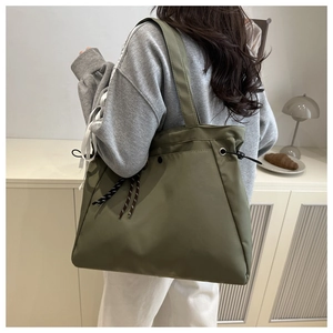 Detail of olive green large nylon tote bag with drawstring and stripe ribbon accents