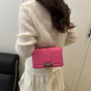 Pink leather crossbody bag with gold chain and flap closure shown on a model