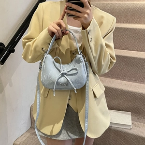 Light blue bow croissant bag with half-moon shape and detachable crossbody strap
