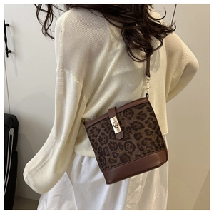 Sac seau à motif léopard avec détails en cuir marron et boucle dorée sur un mannequin