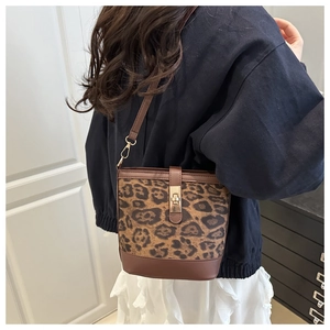 Détail du sac seau à imprimé léopard avec finitions en cuir marron et boucles