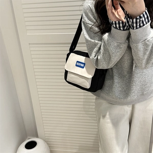 Minimalist canvas crossbody phone bag in black and white with adjustable shoulder strap