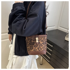 Vue détaillée du sac seau à motif léopard avec fermoir en métal et bandoulière en cuir