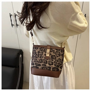 Détail du sac seau à motif léopard avec fermoir doré et bandoulière en cuir réglable