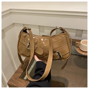 Close-up of khaki brown patent leather bag with silver buckles and sleek shoulder strap