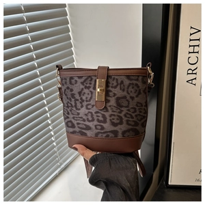 Détail du sac seau à imprimé léopard avec garniture en cuir et fermoir doré rotatif