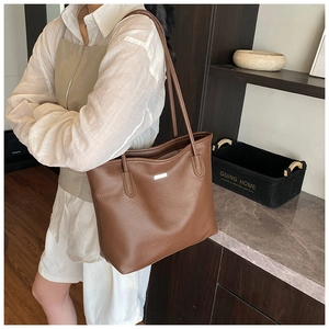 Détail du sac cabas marron caramel à grain litchi avec logo argenté et doubles anses