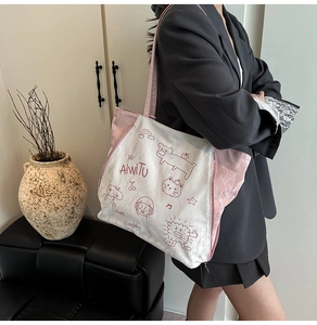 Detailed side view of a pink and white printed tote bag worn by a model in casual setting