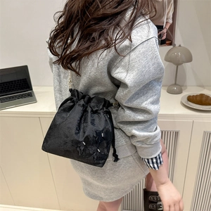 Elegant black embroidered pearl bucket bag with floral patterns and drawstring closure