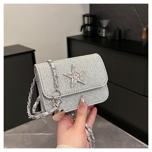 Close-up of silver glitter crossbody bag with large rhinestone star and chain strap