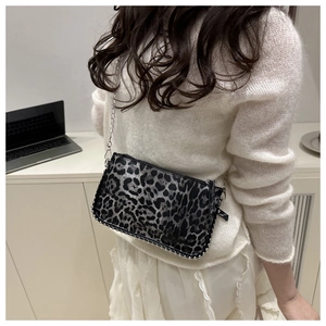 Detailed close-up of leopard print crossbody bag with metallic bead trim on chain strap