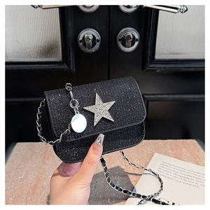 Macro detail of black sequin fabric texture and silver star embellishment on crossbody bag