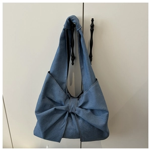 Détail du sac cabas en denim bleu clair avec son design unique en forme de nœud papillon