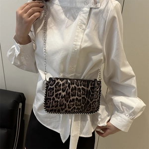 Leopard print crossbody bag with silver studs and chain strap shown on a model