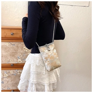 Close-up of a mini floral jacquard crossbody phone bag with traditional embroidery detail