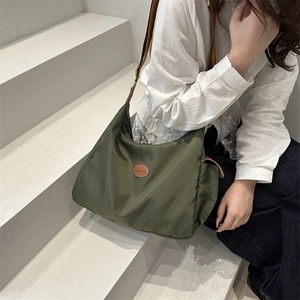 Olive green nylon dumpling bag with adjustable strap and fashion label for daily commute
