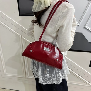 Glossy red shell-shaped underarm bag with silver plaque and slender leather strap