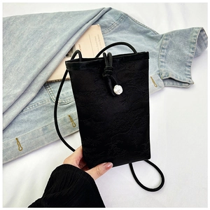 Detailed view of black jacquard mini phone bag with floral buckle and silk texture
