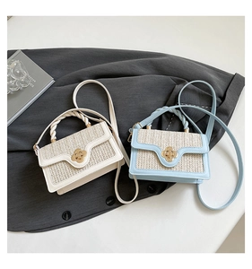 Detail of woven straw handbags in beige and blue with golden flower-shaped twist locks