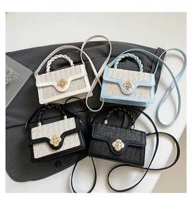 Detail of four woven handbags with gold flower twist locks in cream, blue, and black colors