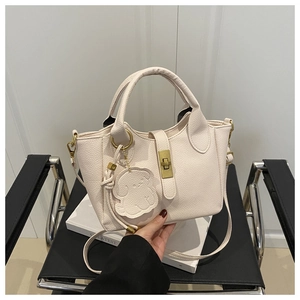 Detailansicht beige Tragetasche mit Litschistruktur, Metalldrehverschluss und Anhänger
