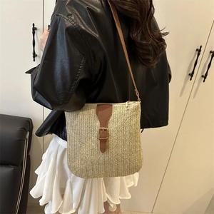 French straw crossbody bag with brown leather flap and gold buckle for beach vacations