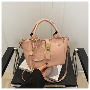 Detailaufnahme der rosa Handtasche aus Litschi-Leder mit goldenem Schloss und Bärenanhänger
